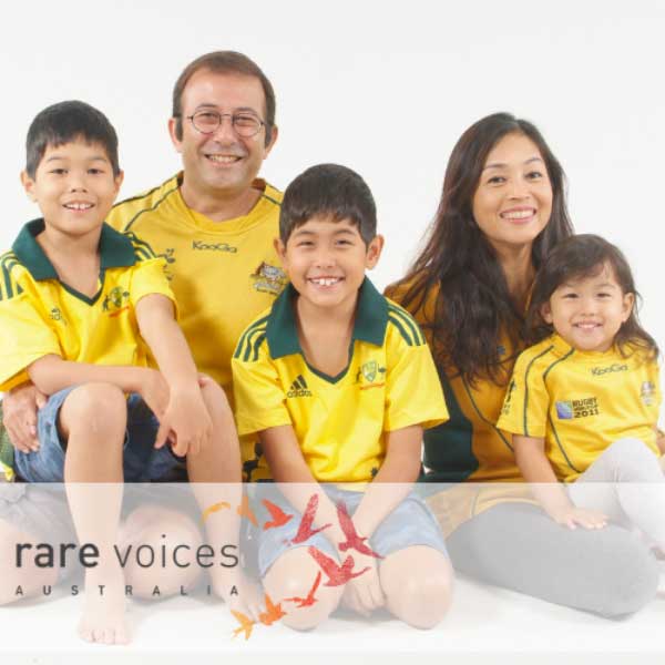 Photo of Adrian and his family dressed in Australian green and gold soccer shirts