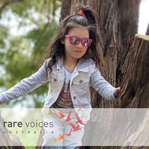 Photo of Emma playing in a tree with sunglasses on